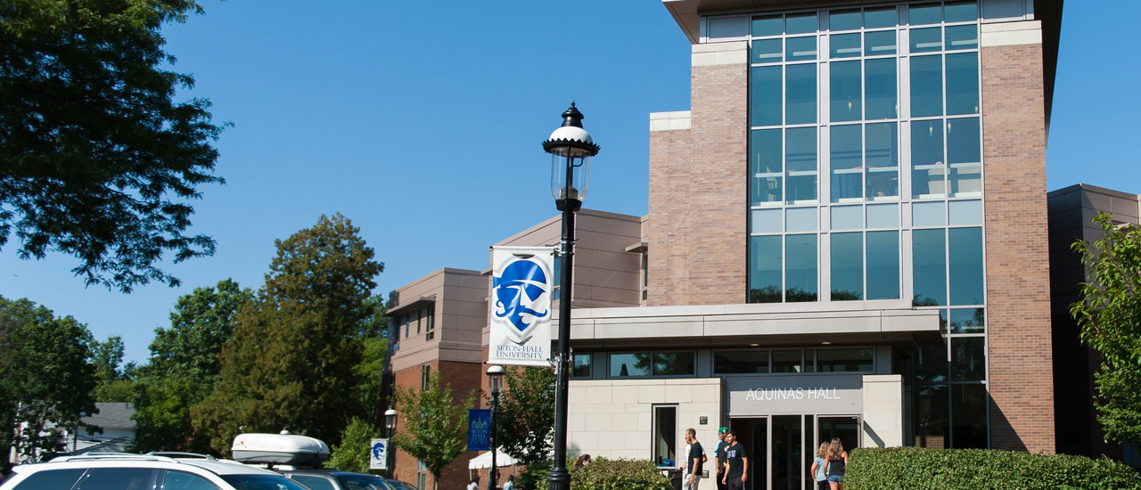 Image of students walking outside aquinas hall. 