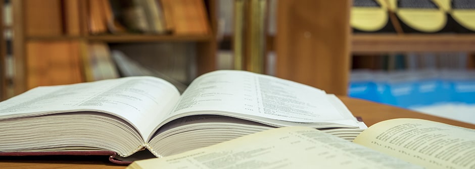 A photo of open books on a table in a Library.