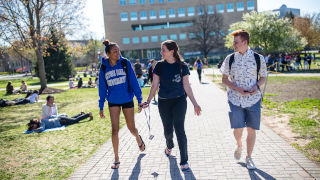 Three students walking away from the quad on campus. 