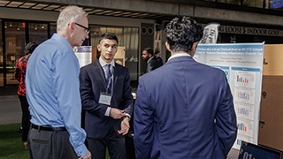 Marco and Aditya pictured presenting research.