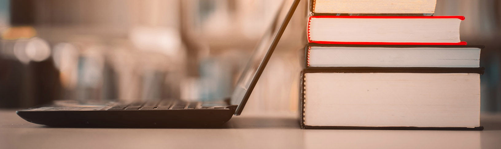 laptop next to a stack of books