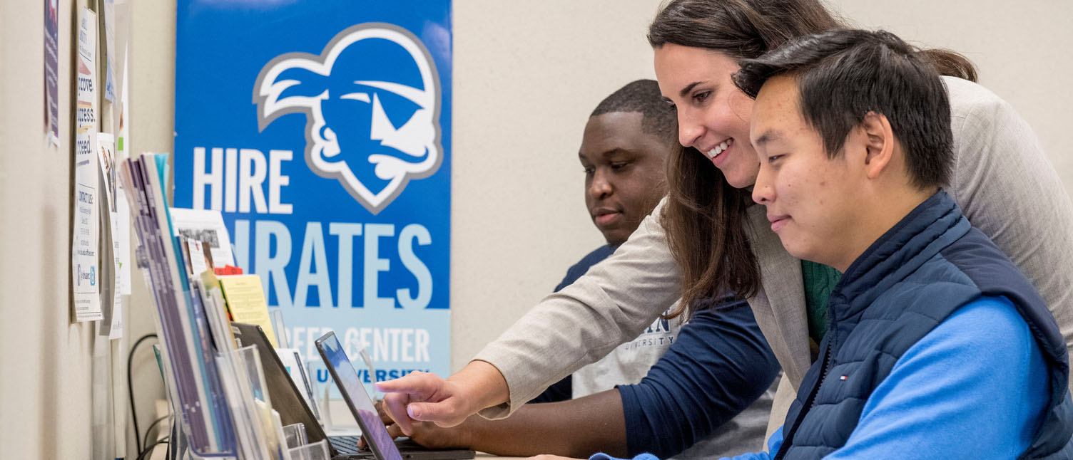 Students and staff working at a computer in the Career Center