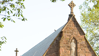 Image of the top of the chapel hidden by trees. 