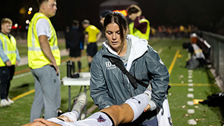 Image of Claire Ralston providing clinical aid to an athlete.