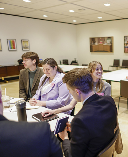 Students sitting around a conference table doing work.