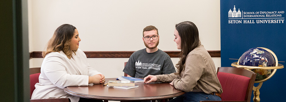 Diplomacy students sitting around a conference table.