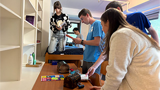 Students solving puzzles in a dorm room escape room activity.