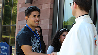 Father Nick greeting students outside Bethany Hall