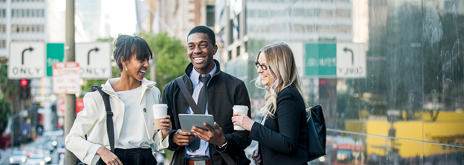 A group of graduate students drinking coffee outside a building. 