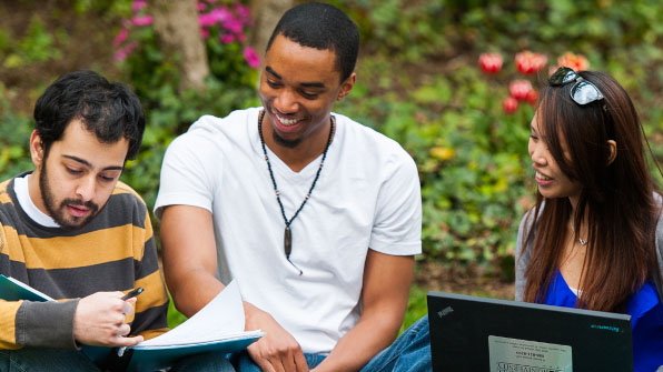 Three Seton Hall students reading on the Green