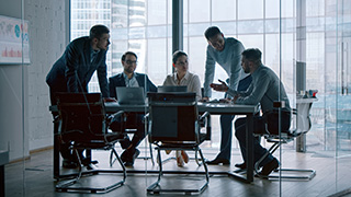People sitting around a conference table in a business setting.