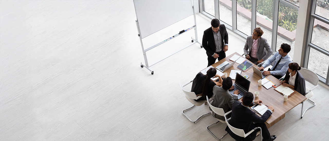 People in sitting around a conference table in a business setting.