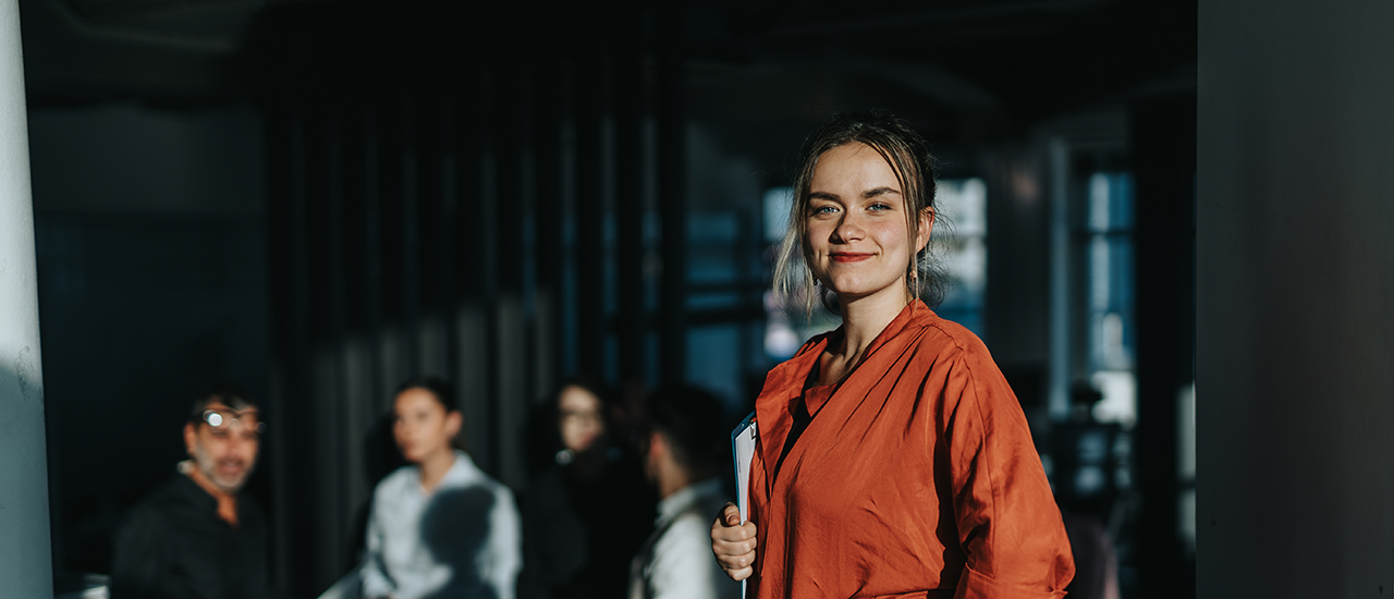In Focus with Jessica Moran ‘23 A woman in a business conference room with business men in the background.