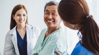 Image of two nurses speaker to a patient. 