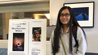 Lili Zeng standing near a poster about her lecture