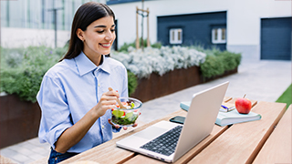 student shaving lunch while in front of a laptop