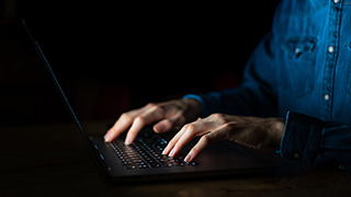 A man typing on a laptop