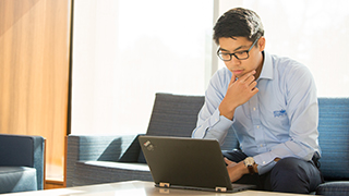 man-sitting-and-looking-at-a-laptop