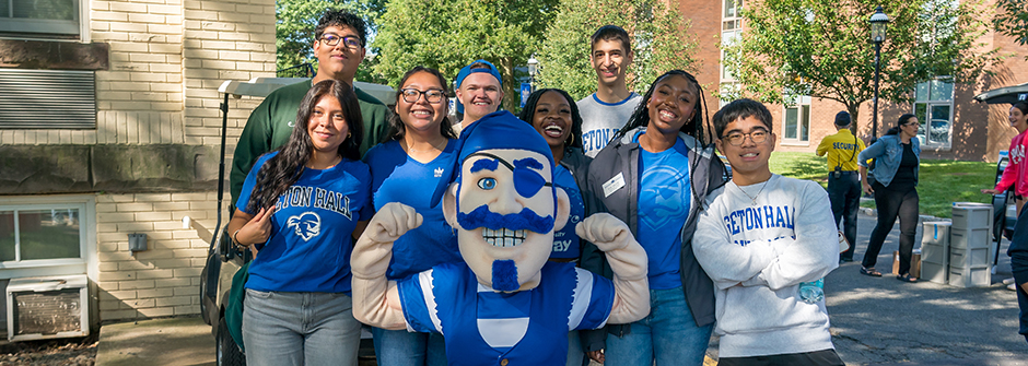 Two parents and a student standing in front of a car during move-in day. 