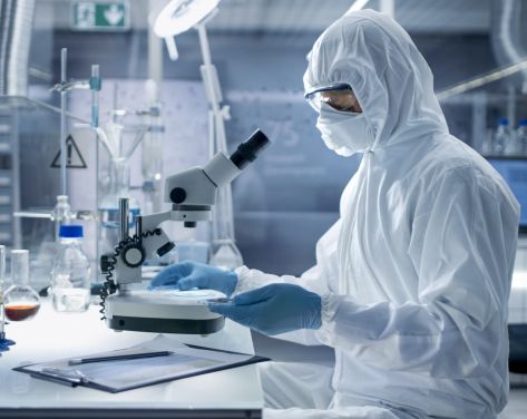 An image of a chemist looking into a microscope