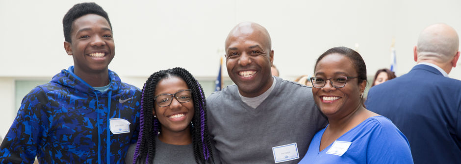 Parents smiling with their student. 