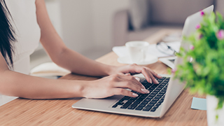 A girl typing on a laptop