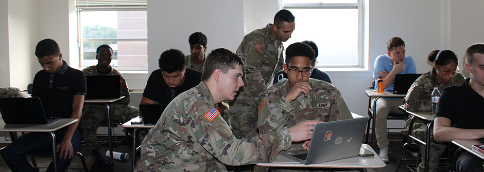 ROTC Cadets sitting in a classroom helping new cadets enroll. 