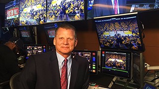 Permanent Diaconate Convocation Man smiling for a photo with monitors in the background