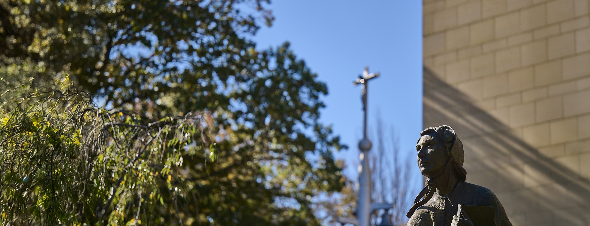 A photo of the Mother Seton statue and bell tower in front of Jubilee Hall.