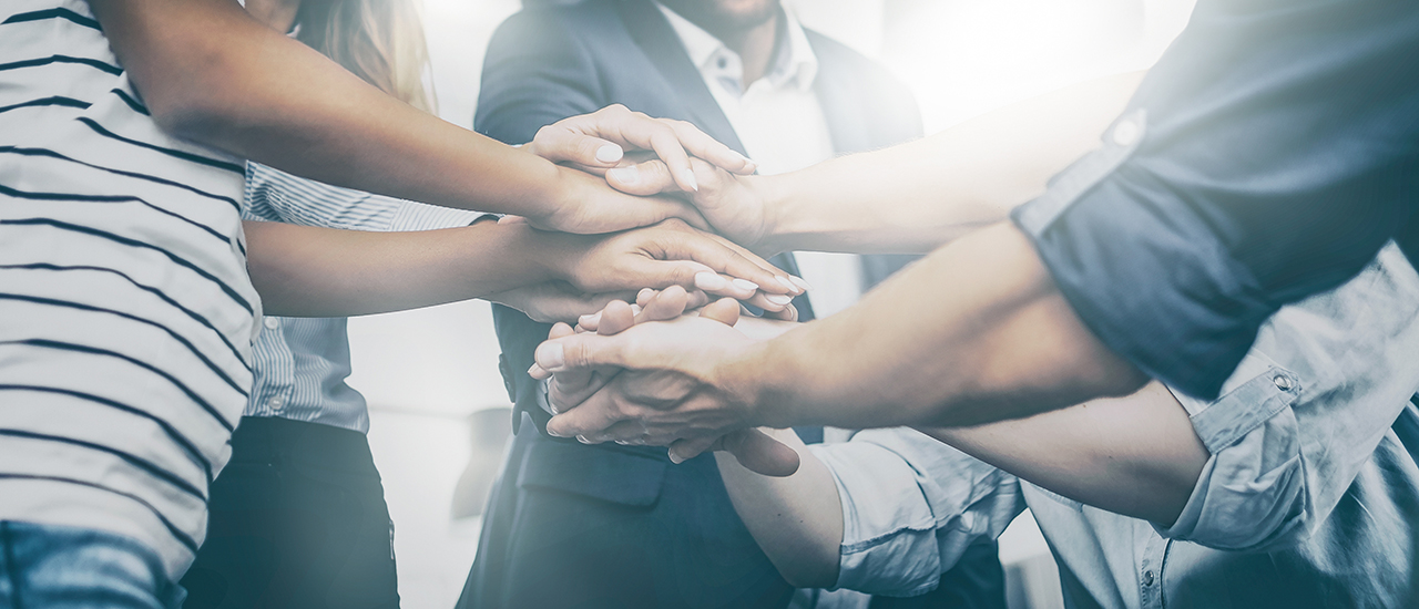 A team of people stacking their hands together.