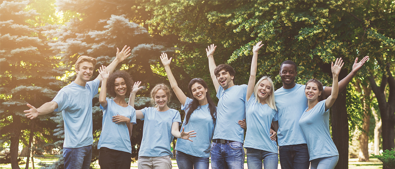 Image of men and women smiling in blue shirts