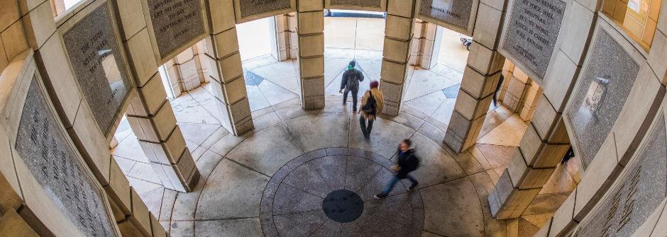 Students walking underneath the Walsh Library Rotunda.