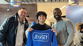 student winning a sweater at the Pirate watch party raffle