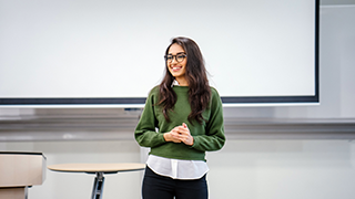 woman standing in front of the room speaking or presenting 